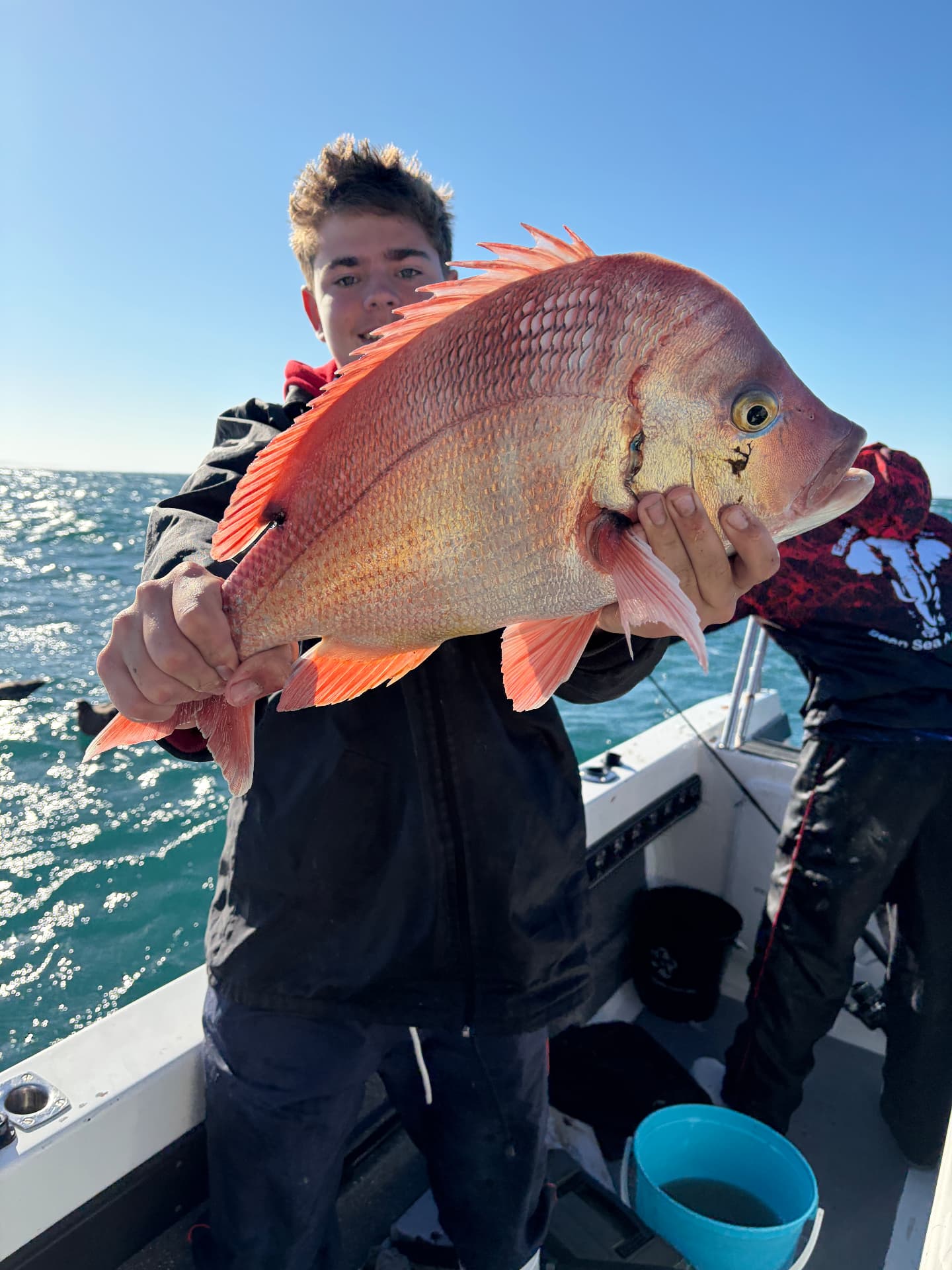 Young angler holding a fish on the deck of the On Point boat