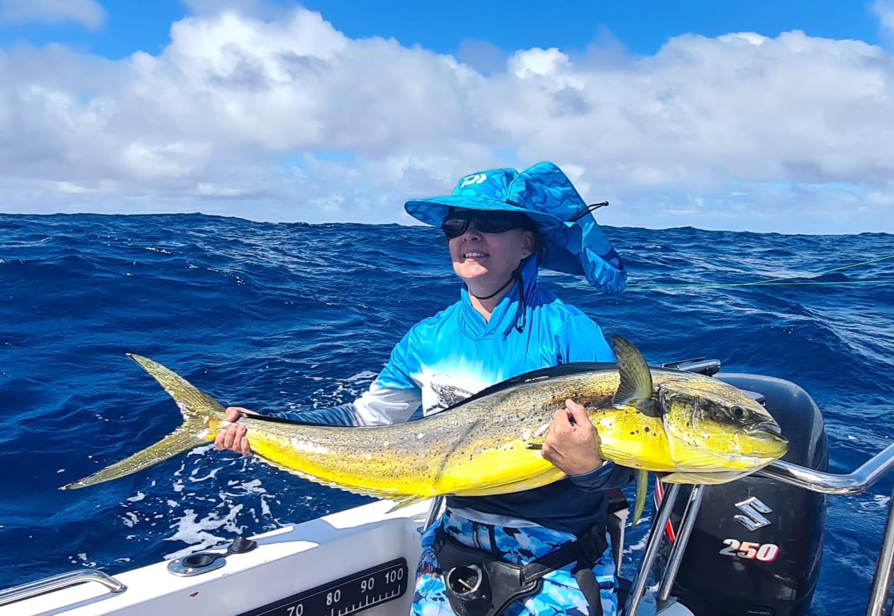 Angler holding a bright dorado on the open ocean off Port Alfred
